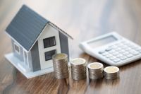 Foto: Modellhaus, Münzstapel und Taschenrechner